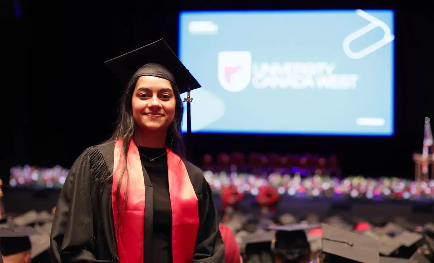 graduate, new alumna, in front of large crowd