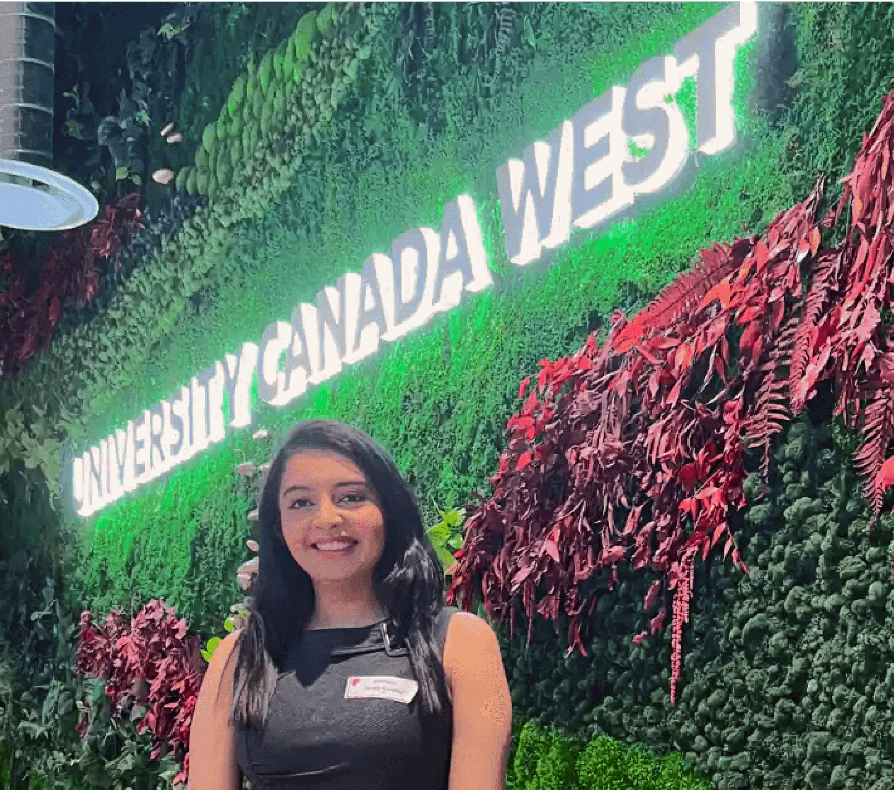 Student standing in front of a UCW backdrop